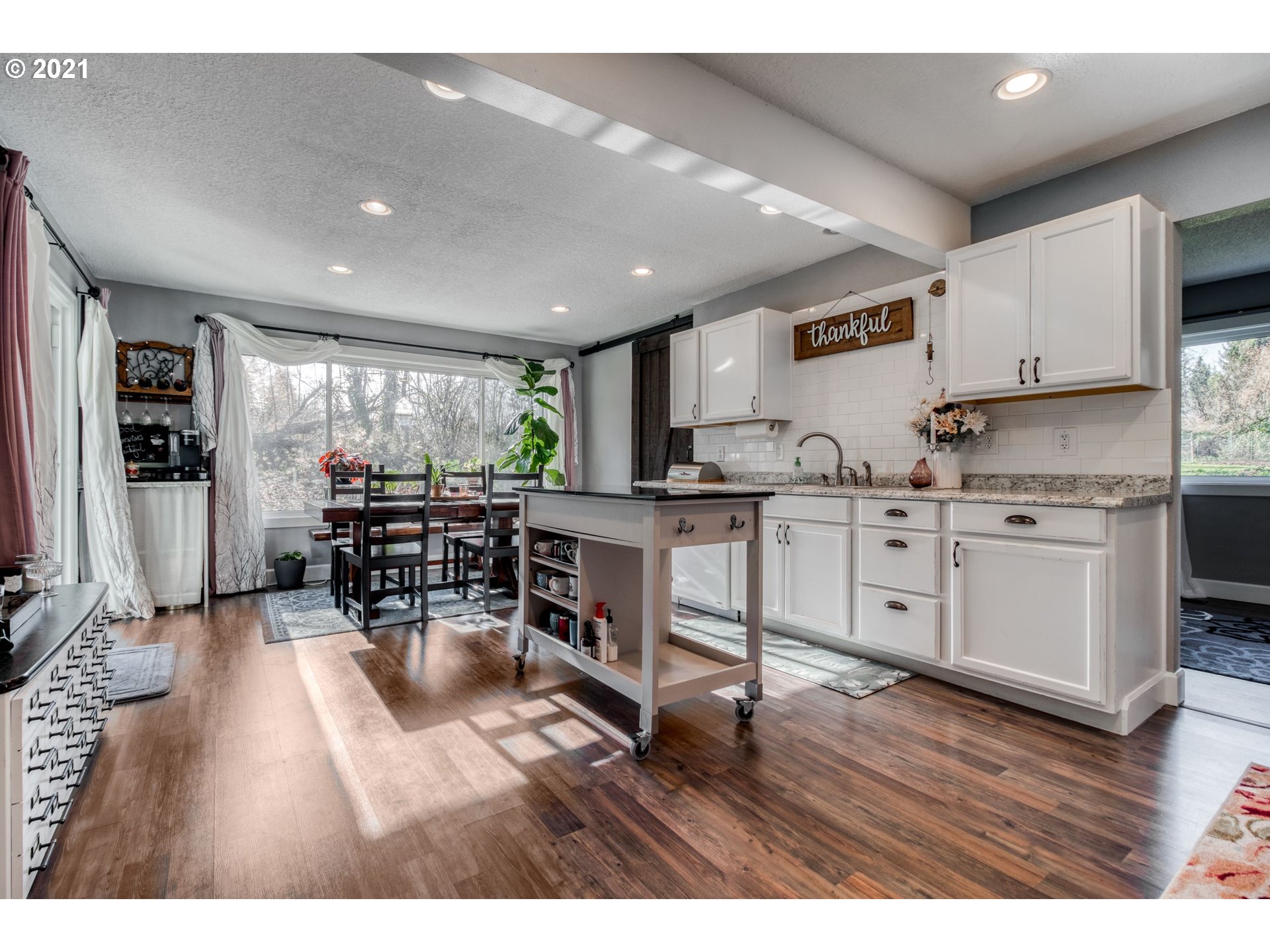 1913 Northeast 199th Street Ridgefield, WA 98642 - Photo 8 of 30 a open kitchen with stainless steel appliances granite countertop a stove top oven a sink a dining table and chairs with wooden floor