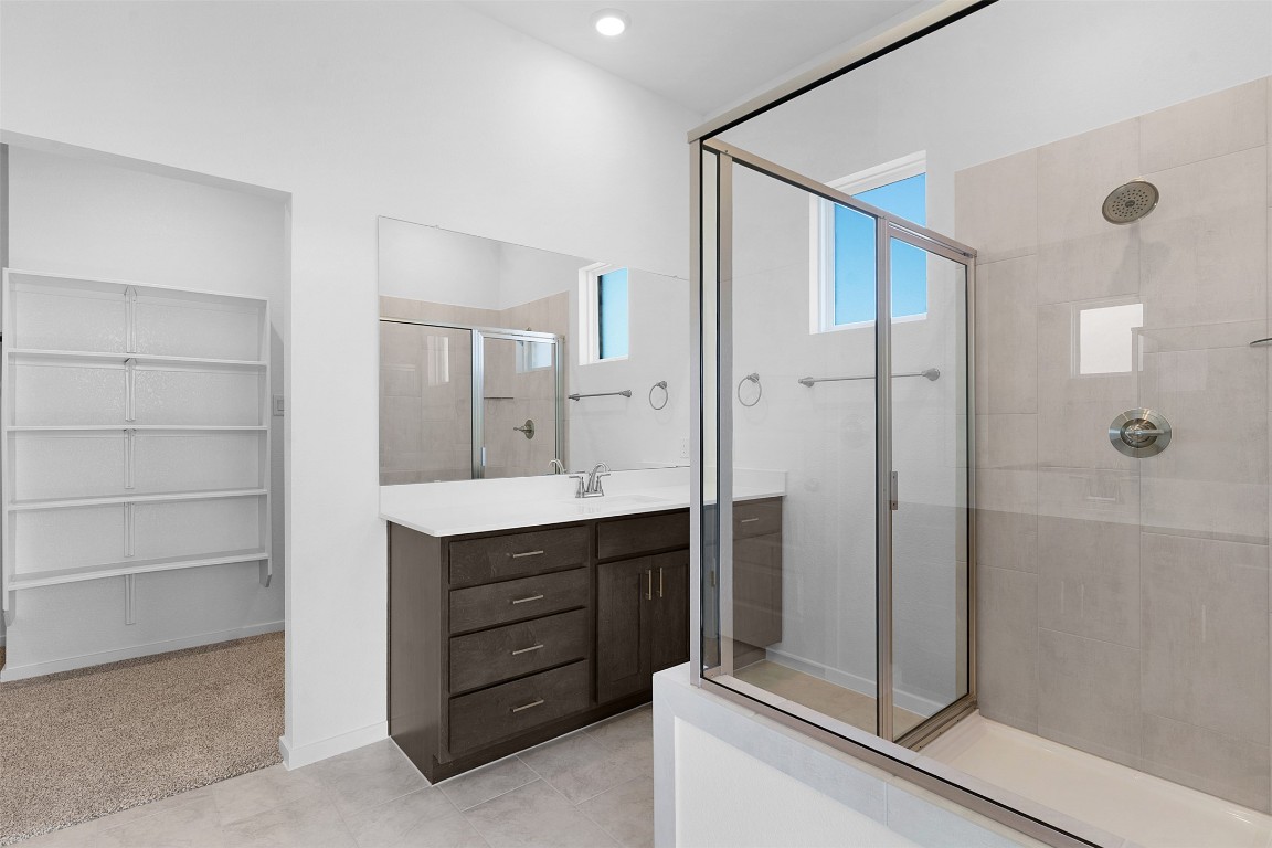 417 Raleigh Drive Georgetown, TX 78633 - Photo 12 of 29 Full bath with vanity, a stall shower, light carpet, a spacious closet, and light tile patterned floors