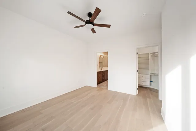 a view of a big room with wooden floor and windows