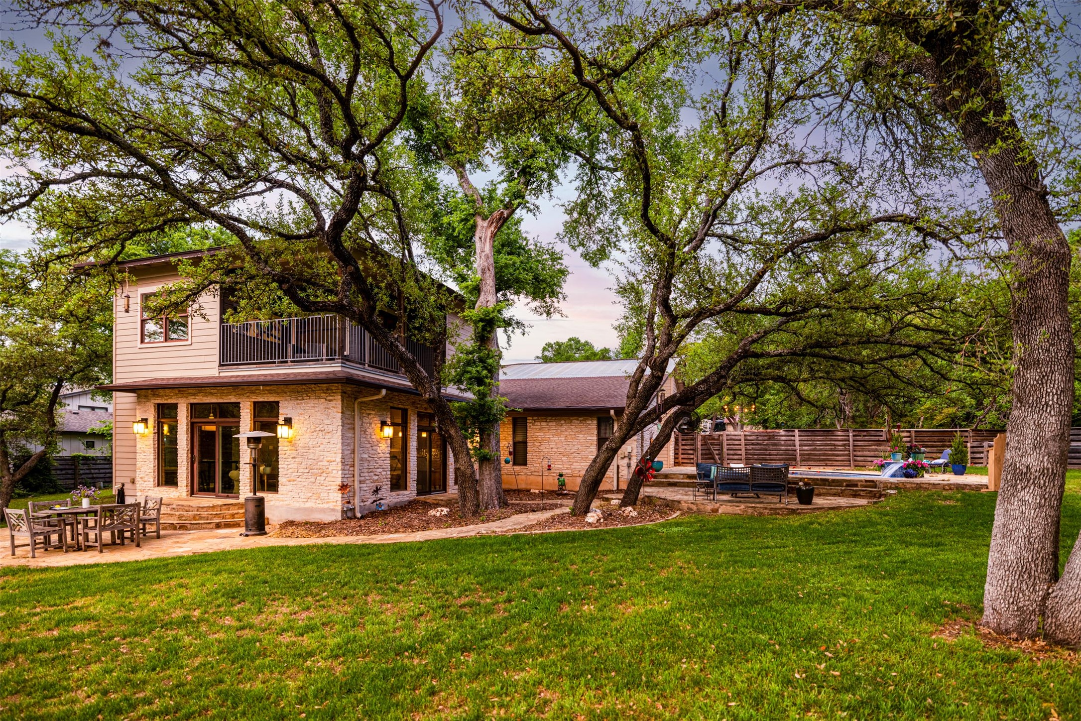 10903 Cade Circle Austin, TX 78726 - Photo 11 of 40 Back of property at dusk featuring a patio area, a balcony, and brick siding