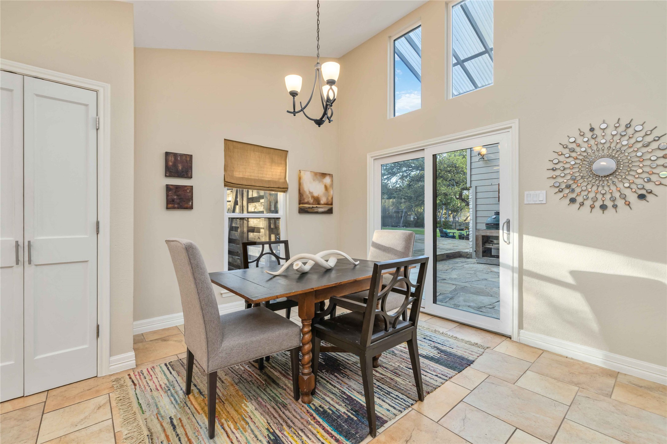 10903 Cade Circle Austin, TX 78726 - Photo 20 of 40 Dining area with suspended lighting, a high ceiling, and light stone finish flooring