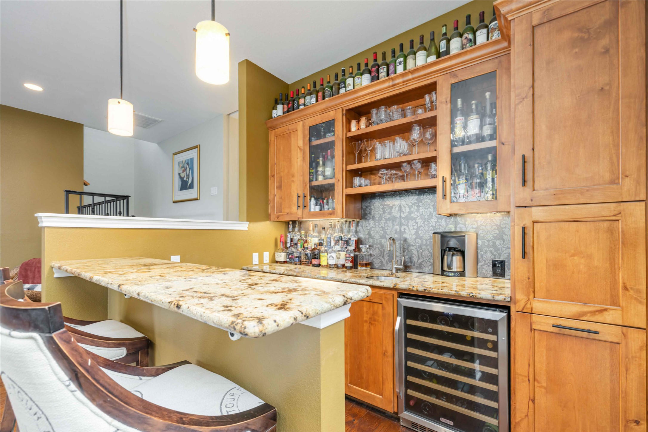 10903 Cade Circle Austin, TX 78726 - Photo 6 of 40 Bar area with light stone counters, wine cooler, glass fronted cabinets, open shelves, and decorative light fixtures