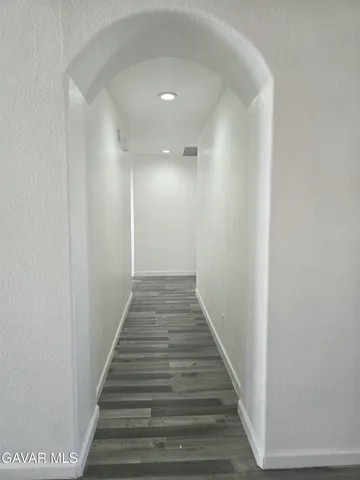 a view of a hallway with wooden floor and entryway