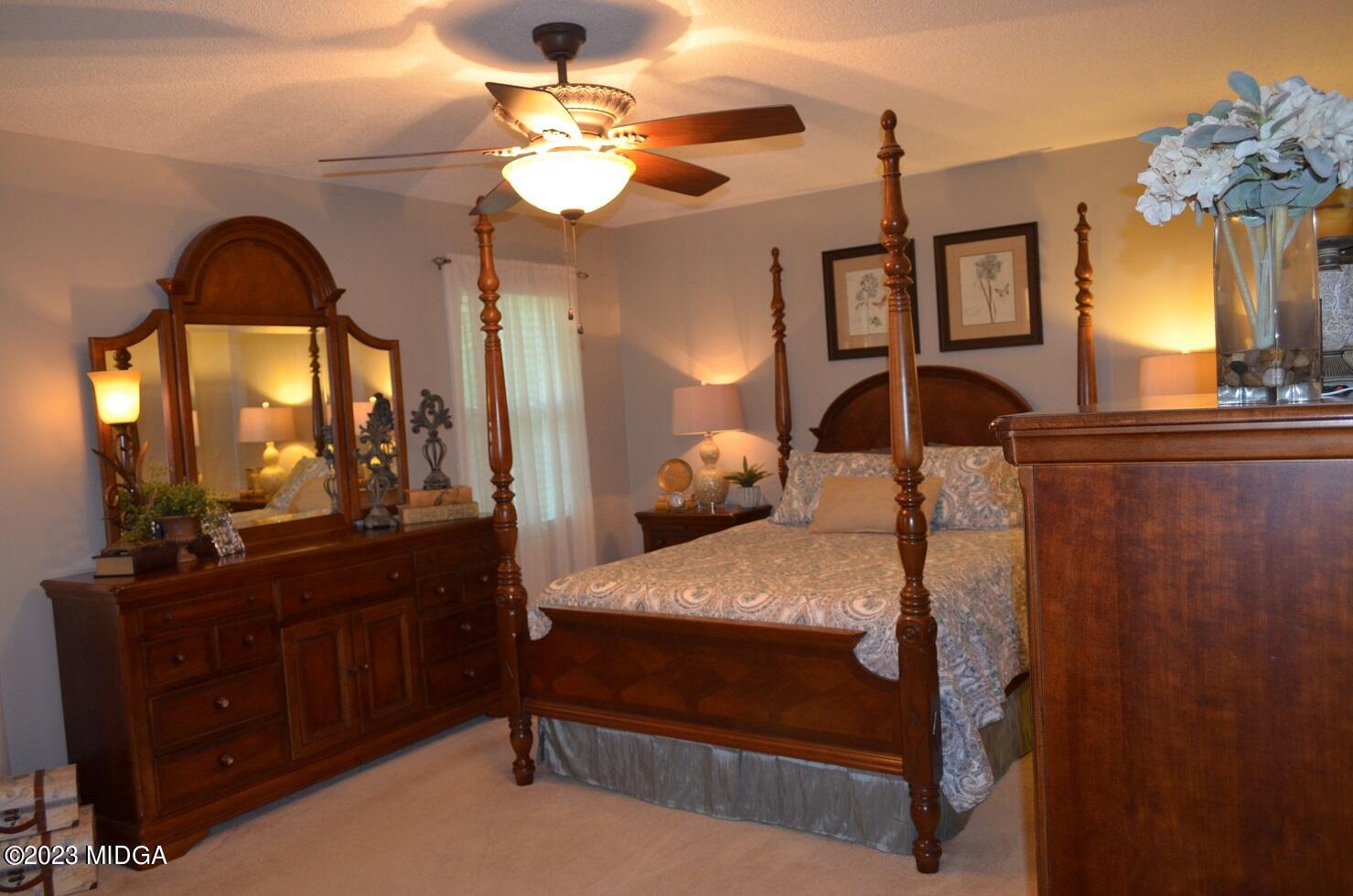 76 Riverside Landing Macon, GA 31210 - Photo 19 of 44 a bedroom with a bed a mirror on dresser and a chandelier