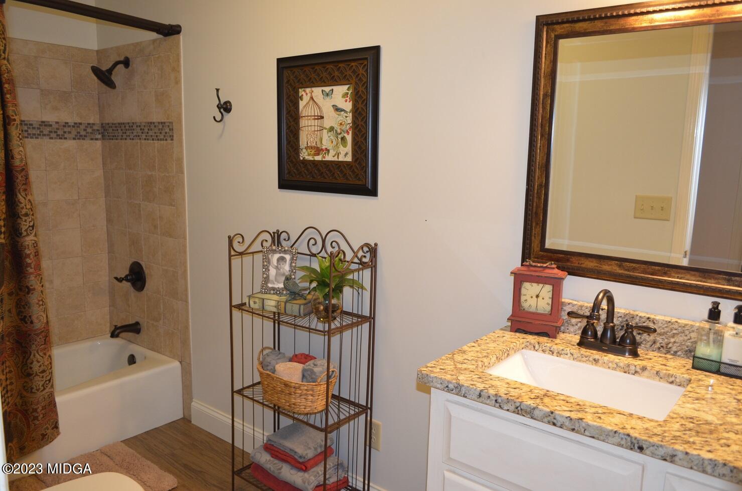 76 Riverside Landing Macon, GA 31210 - Photo 26 of 44 a bathroom with a granite countertop sink a mirror a bathtub and shower