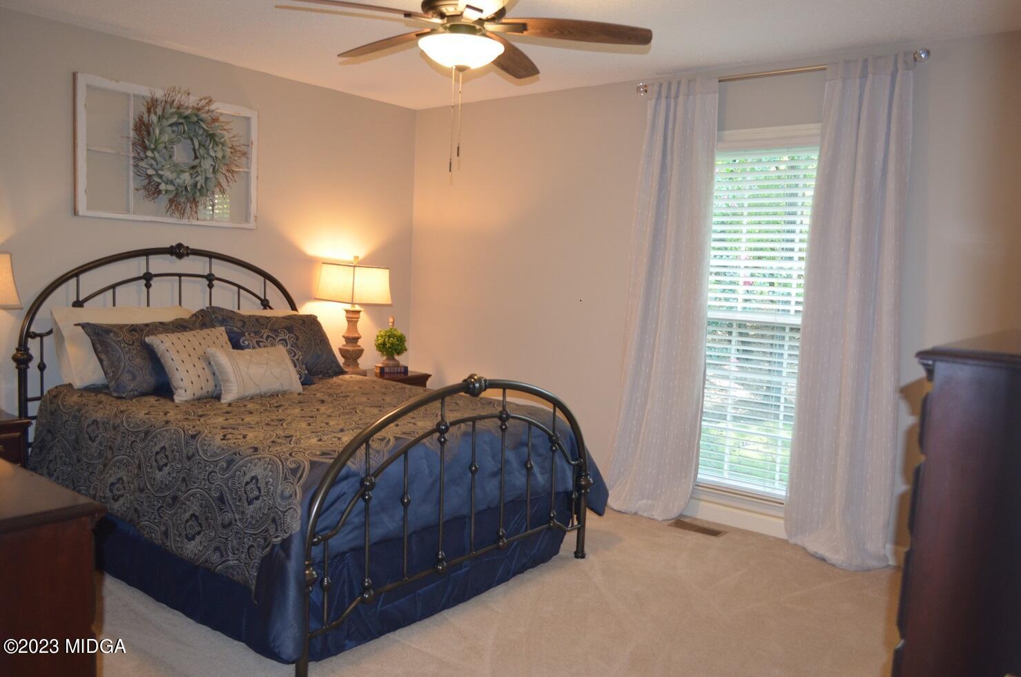 76 Riverside Landing Macon, GA 31210 - Photo 27 of 44 a bedroom with a bed a window and a chandelier