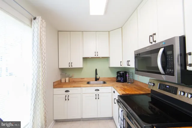 a kitchen with stainless steel appliances a stove a refrigerator and a microwave