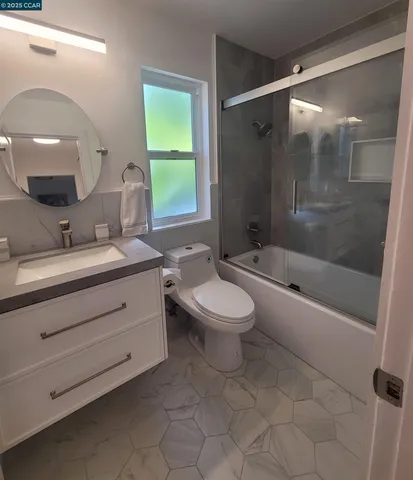 a bathroom with a double vanity sink toilet mirror and bathtub