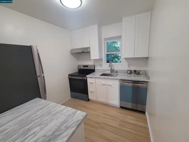 a kitchen with a stove a refrigerator and a dining table