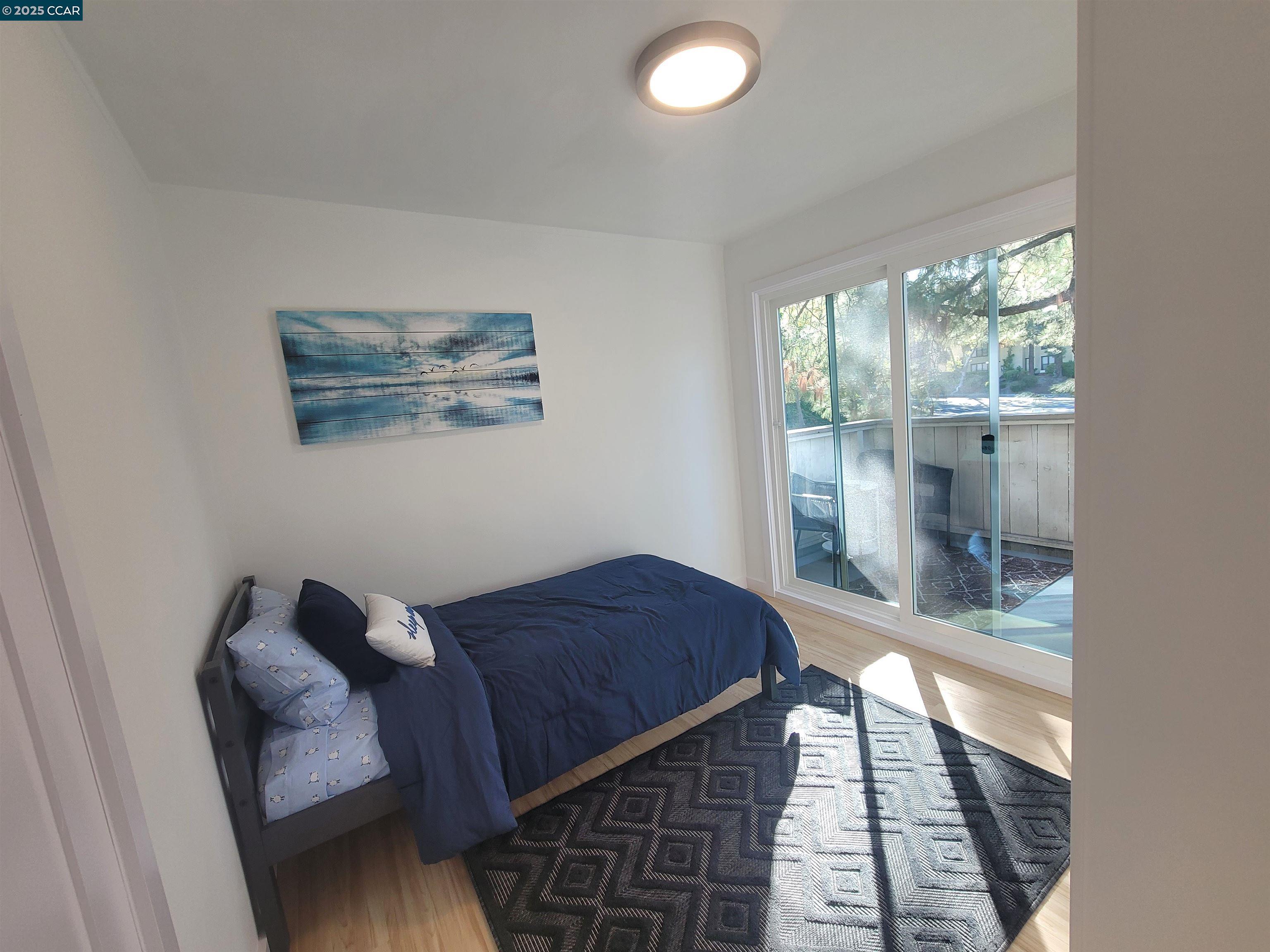 375 Camelback Road, Unit 23 Pleasant Hill, CA 94523 - Photo 40 of 58 a bedroom with a bed and wooden floor