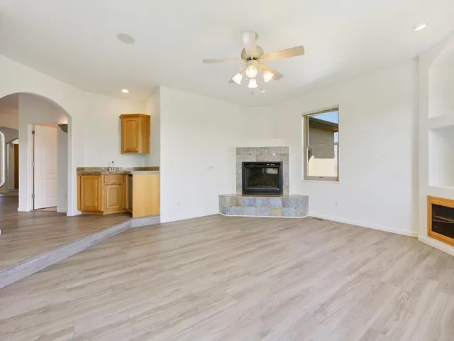 a view of an empty room with a fireplace and a window