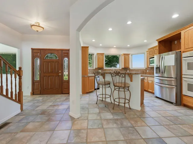 a kitchen with granite countertop a refrigerator and a sink