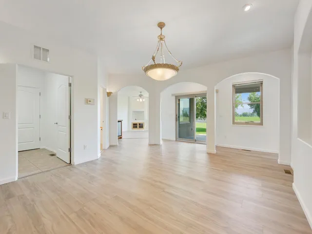 a view of an empty room with window and wooden floor