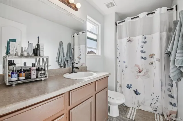 a bathroom with a double vanity sink toilet and shower