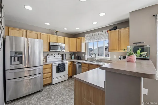 a kitchen with kitchen island granite countertop a sink stainless steel appliances and window