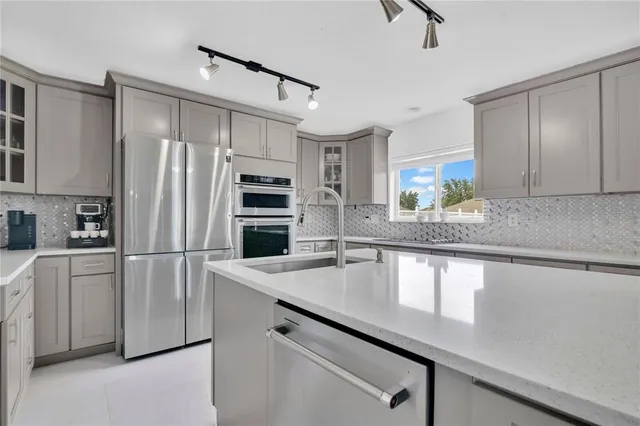 a kitchen with stainless steel appliances a refrigerator sink and stove
