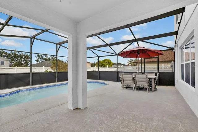 a view of a patio with a table and chairs under an umbrella