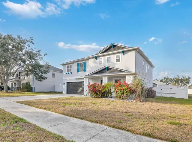 a front view of a house with a yard and potted plants