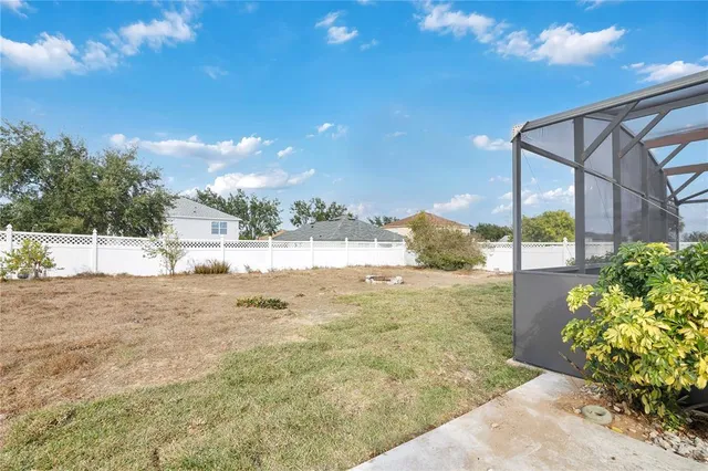 a view of a big house with a big yard and large trees