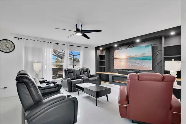 a living room with furniture a flat screen tv and a large window