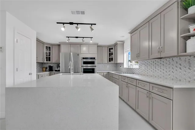 a kitchen with stainless steel appliances a refrigerator sink and microwave