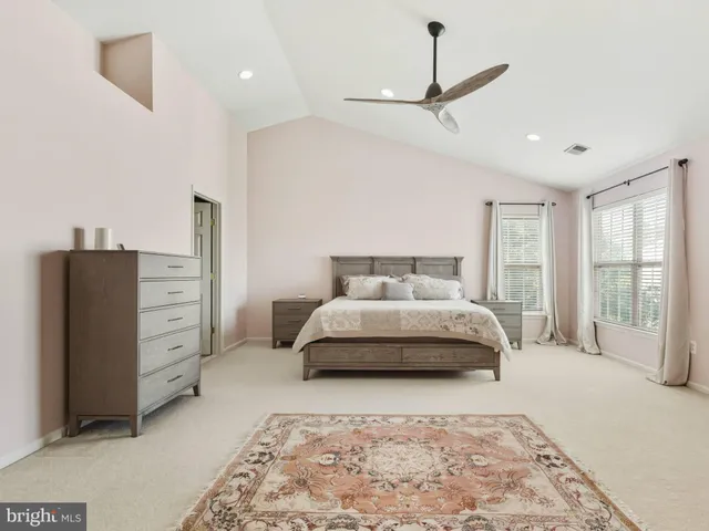 a spacious bedroom with a bed and a dresser