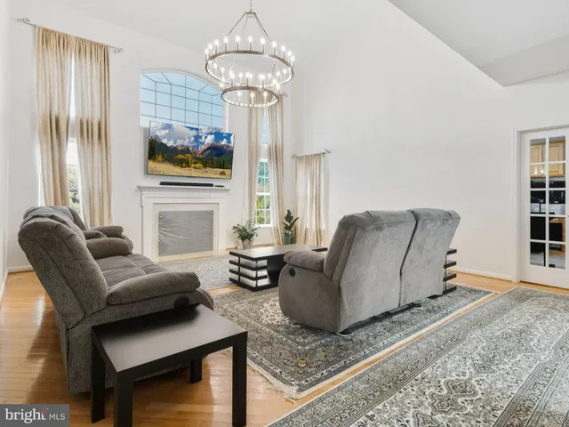 a living room with furniture a chandelier and a flat screen tv