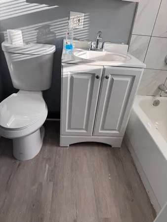 a bathroom with a toilet sink and mirror