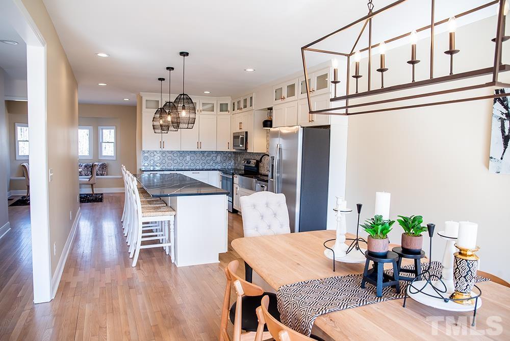 433 Noah Davis Road Roxboro, NC 27574 - Photo 21 of 95 a living room with kitchen island furniture and a chandelier