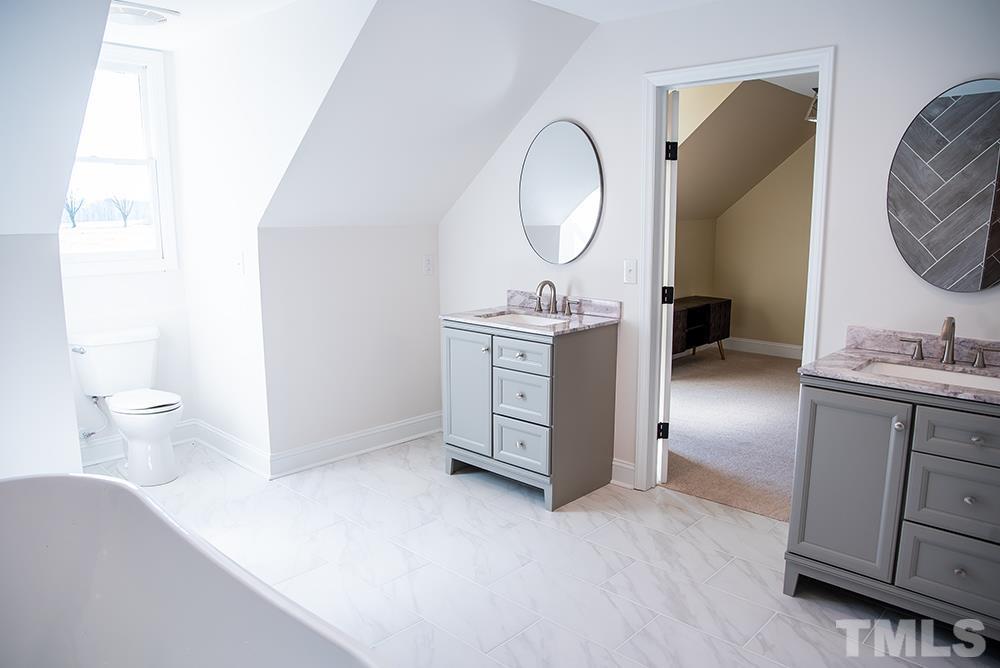 433 Noah Davis Road Roxboro, NC 27574 - Photo 73 of 95 a en suite bathroom with a granite countertop sink and a mirror