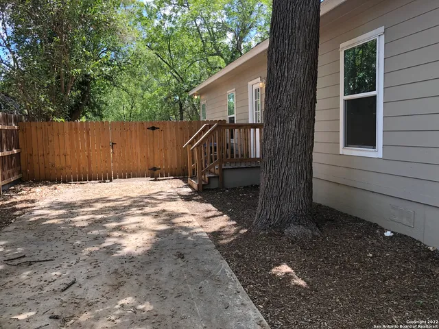 a view of backyard with small cabin and wooden fence