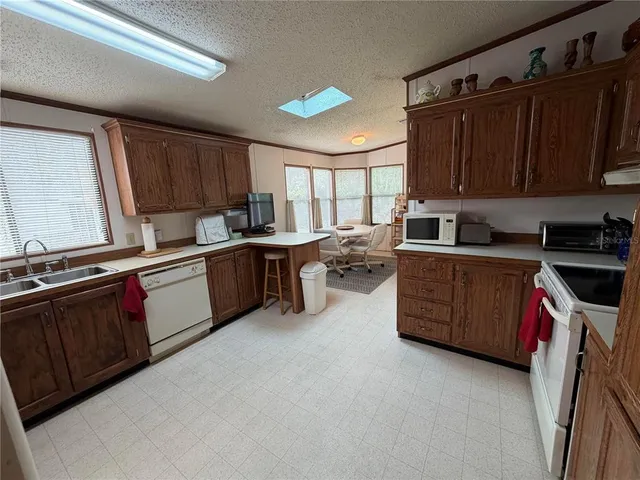 a kitchen with sink a microwave and cabinets