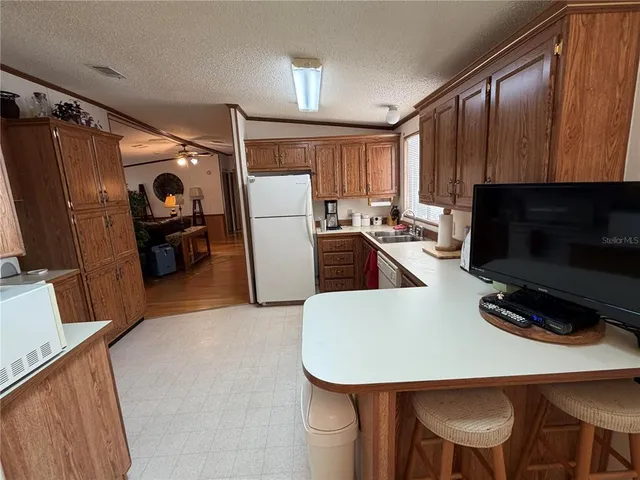 a kitchen with a table chairs refrigerator and microwave