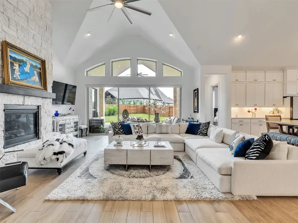 a living room with furniture fireplace and a large window