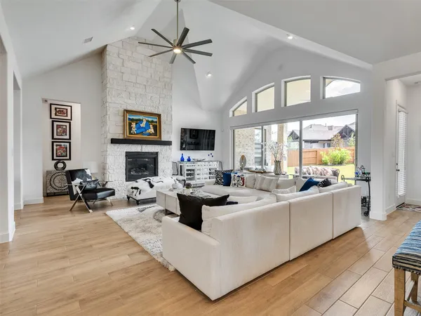 a living room with furniture fireplace and a large window