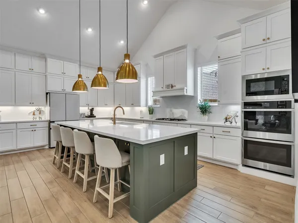 a kitchen with a sink cabinets and wooden floor