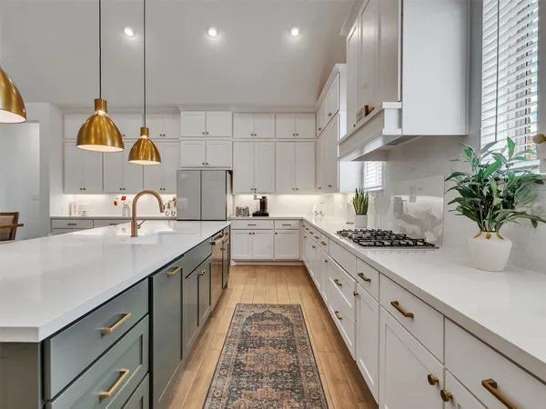 a kitchen with kitchen island granite countertop a sink stainless steel appliances and cabinets