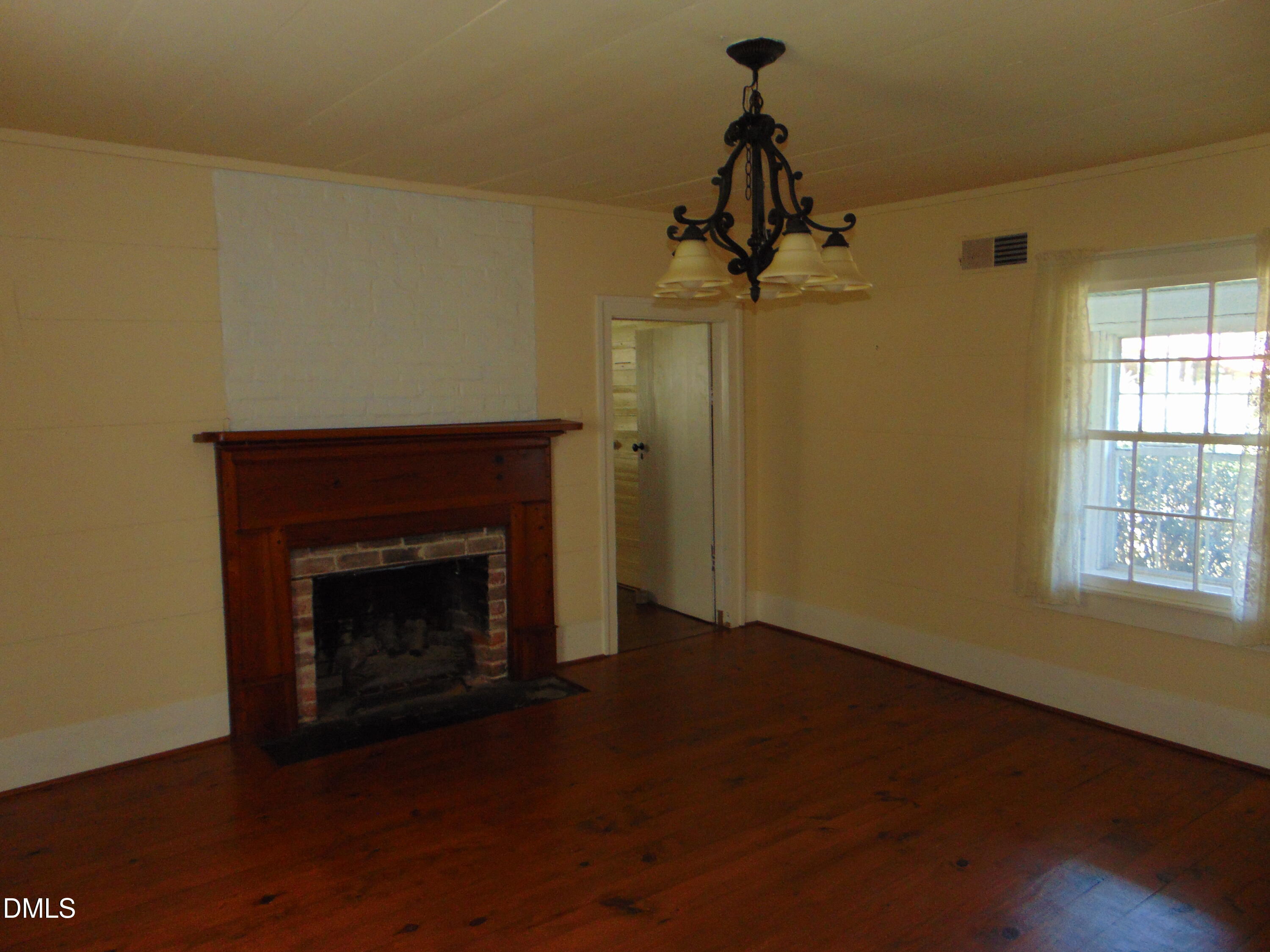 4067 Chewning Road Oxford, NC 27565 - Photo 63 of 82 a view of an empty room with wooden floor fireplace and a window