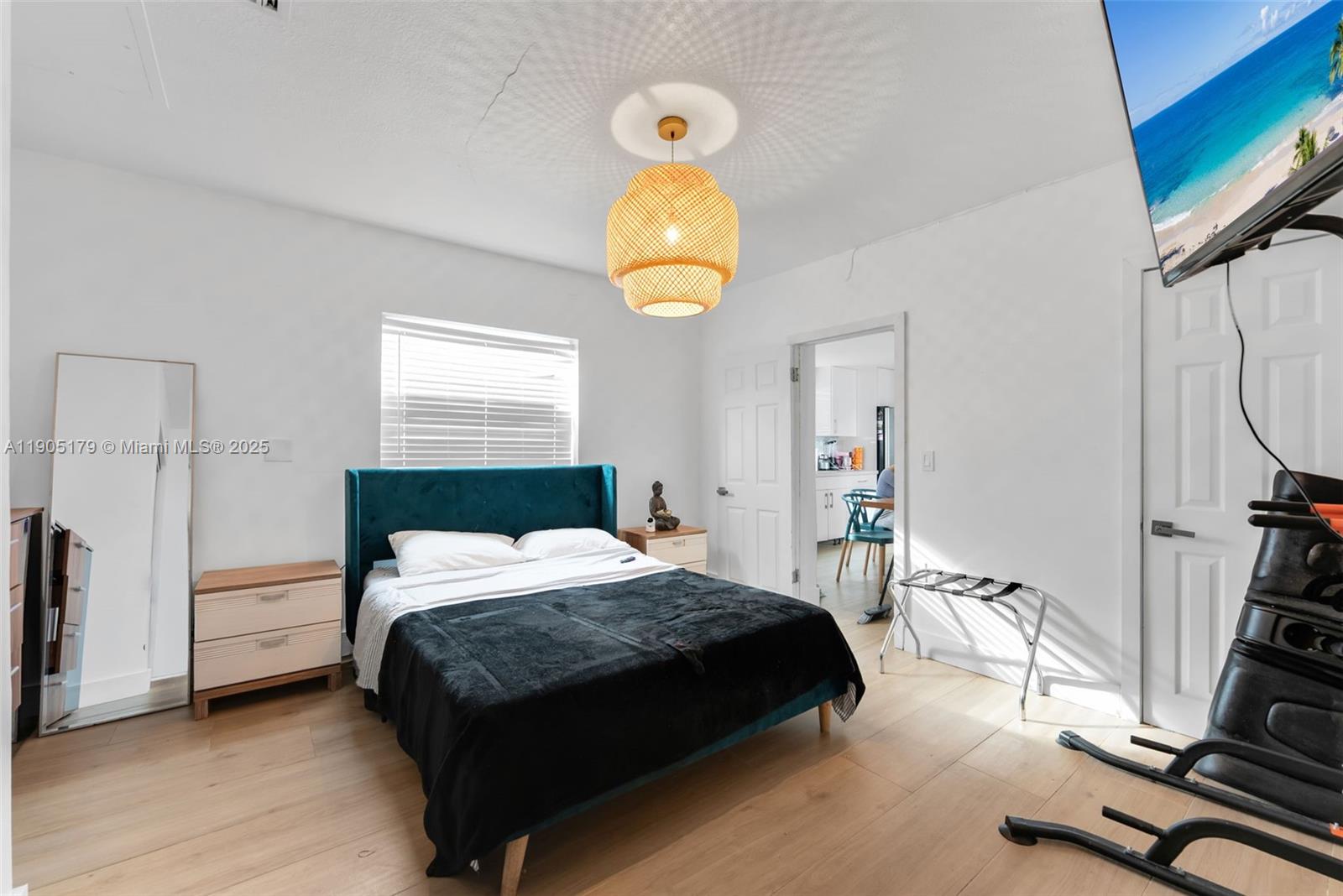 1105 Northeast 10th Street Hallandale Beach, FL 33009 - Photo 16 of 28 a bedroom with a bed a chandelier and a window