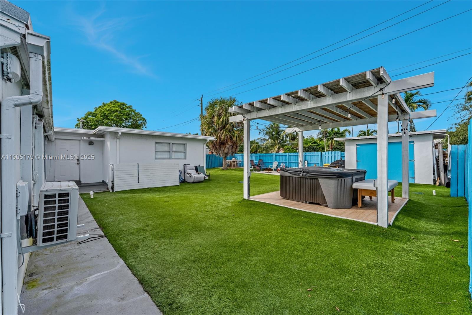 1105 Northeast 10th Street Hallandale Beach, FL 33009 - Photo 25 of 28 a view of a backyard with table and chairs potted plants and a palm tree
