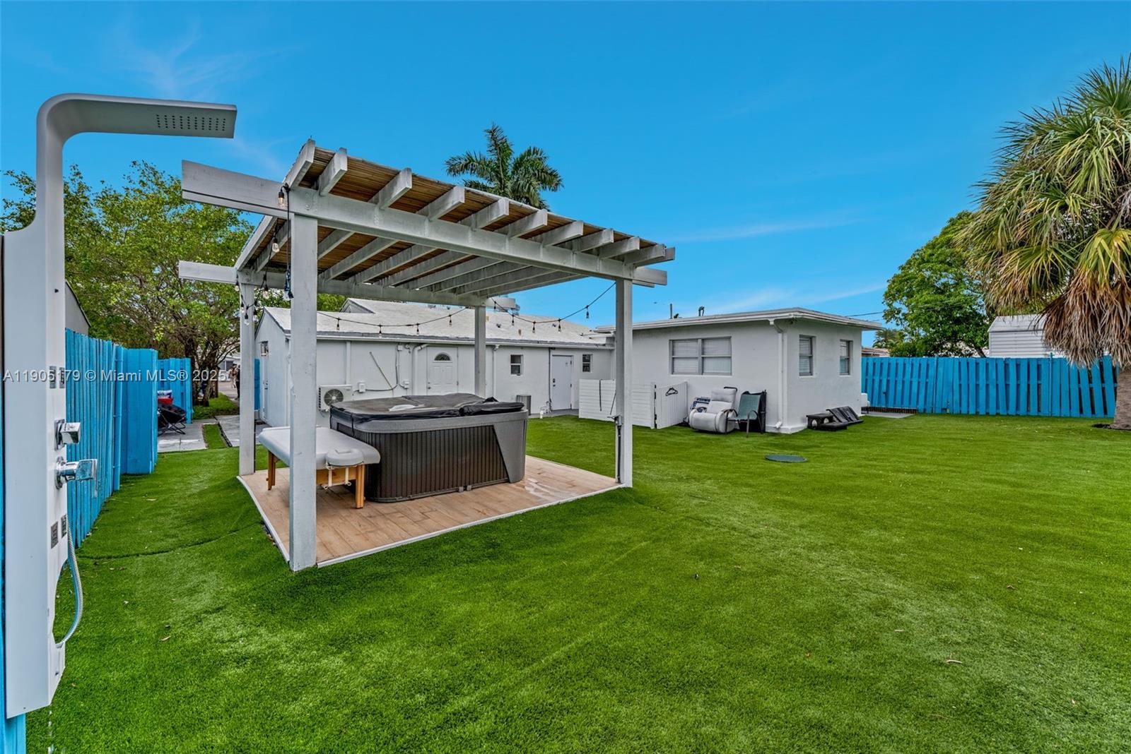 1105 Northeast 10th Street Hallandale Beach, FL 33009 - Photo 26 of 28 a view of a backyard with table and chairs potted plants and a palm tree