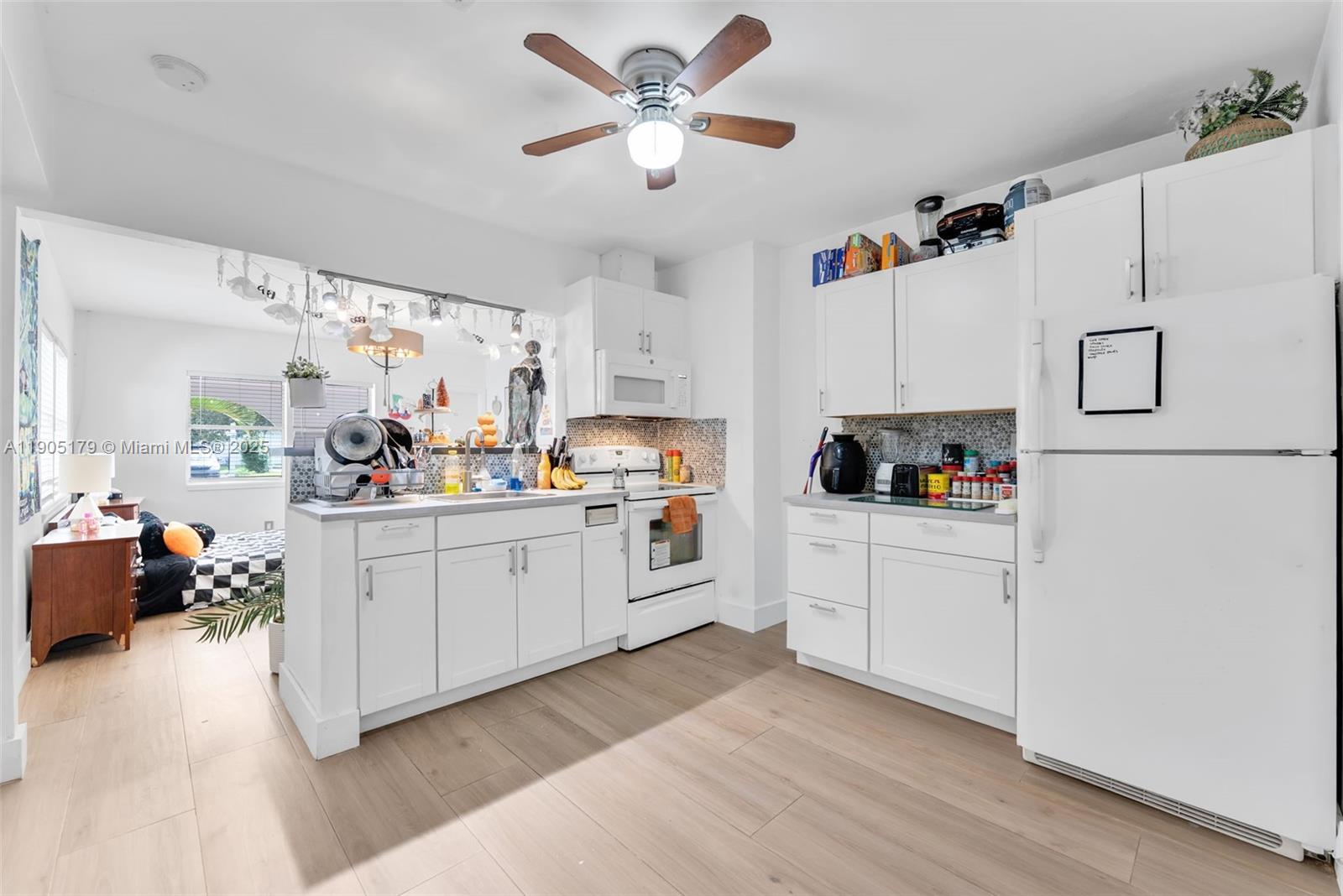 1105 Northeast 10th Street Hallandale Beach, FL 33009 - Photo 8 of 28 a kitchen with white cabinets and white appliances