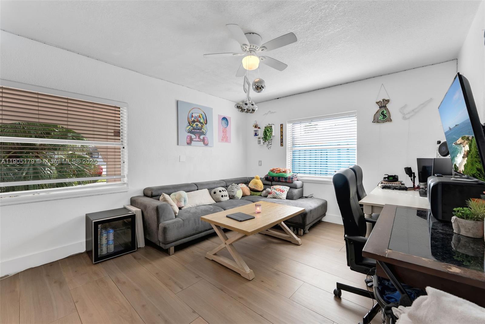 1105 Northeast 10th Street Hallandale Beach, FL 33009 - Photo 9 of 28 a living room with furniture floor to ceiling window and a flat screen tv