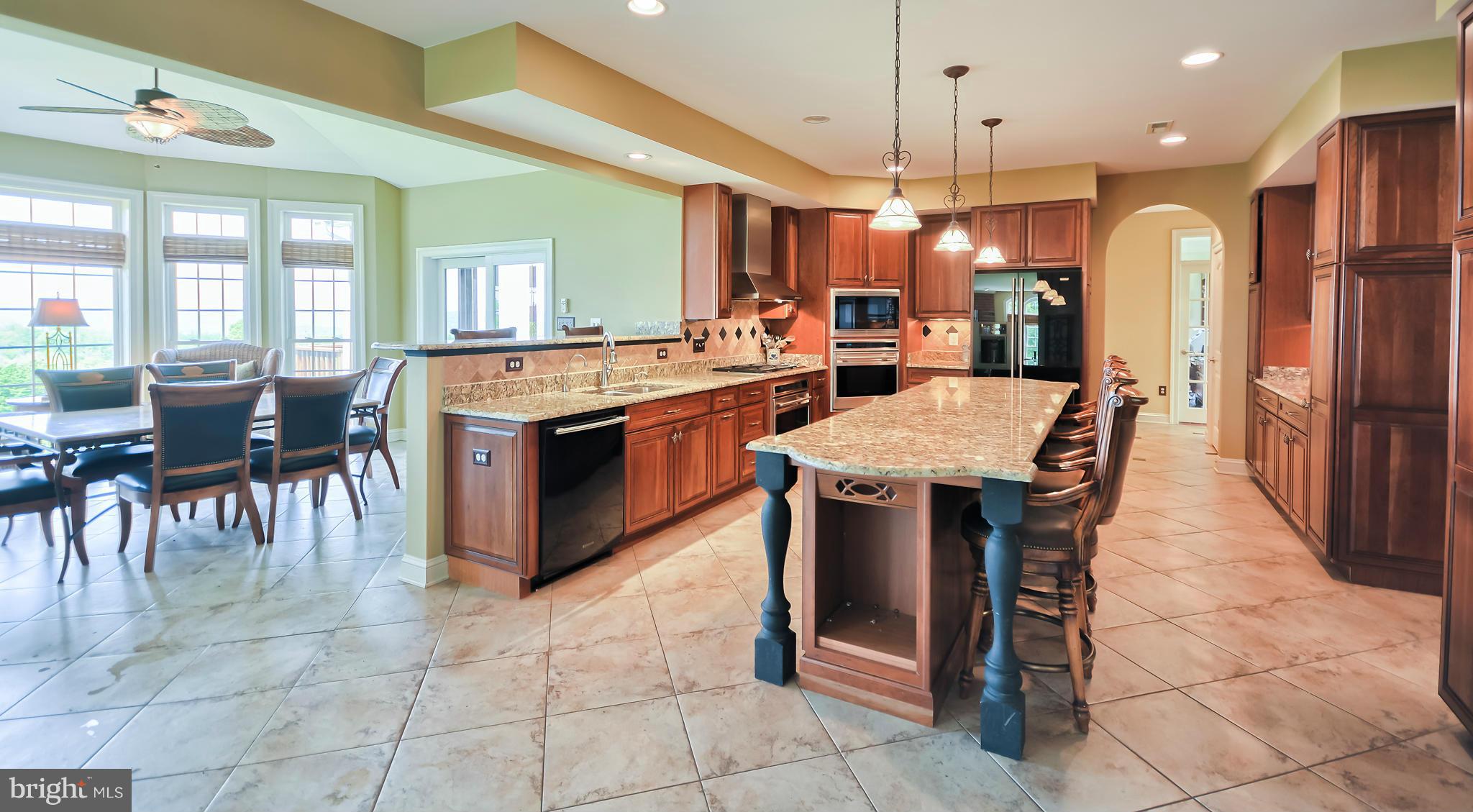 4522 Coxey Brown Road Myersville, MD 21773 - Photo 13 of 30 a kitchen with granite countertop a center island a stove a table and chairs