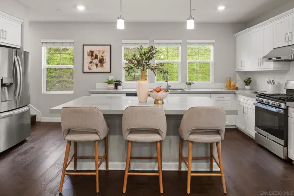 a kitchen with stainless steel appliances granite countertop a stove a sink a stove a dining table and chairs