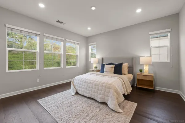 a spacious bedroom with a bed and wooden floor