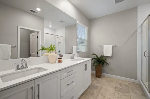 a bathroom with a granite countertop sink a large mirror and a shower