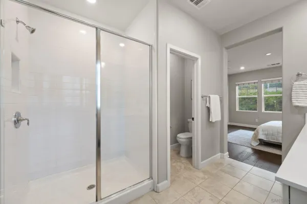 a bathroom with a glass shower door and a window
