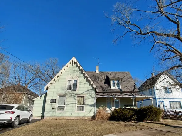 a view of a white building among the street with palm trees
