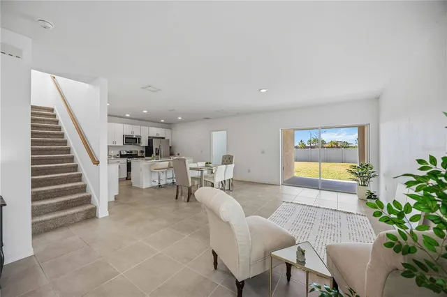 a view of kitchen with refrigerator stove dining table and chairs